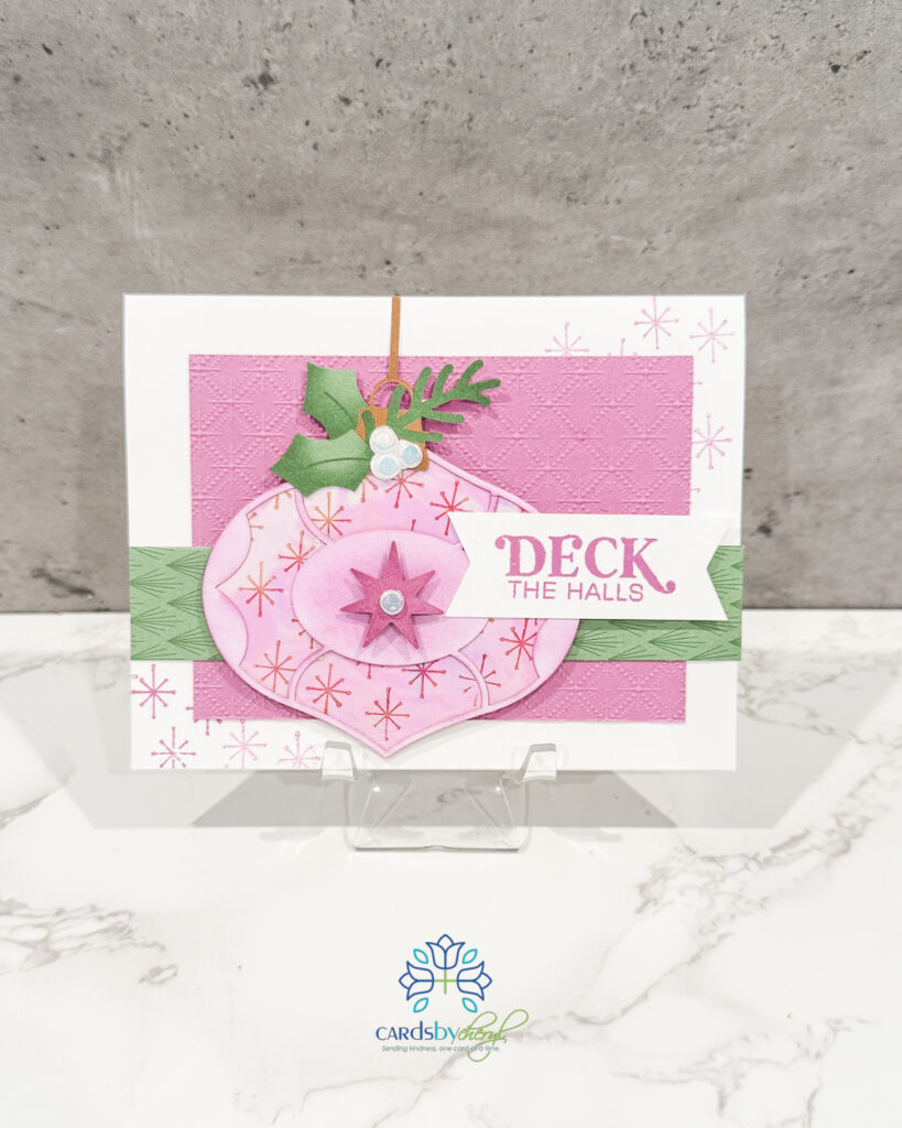 A pink and green card that says "Deck the Halls"